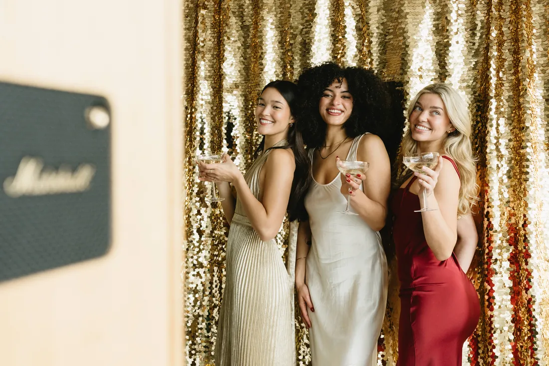 Guests celebrating in front of a gold sequin backdrop